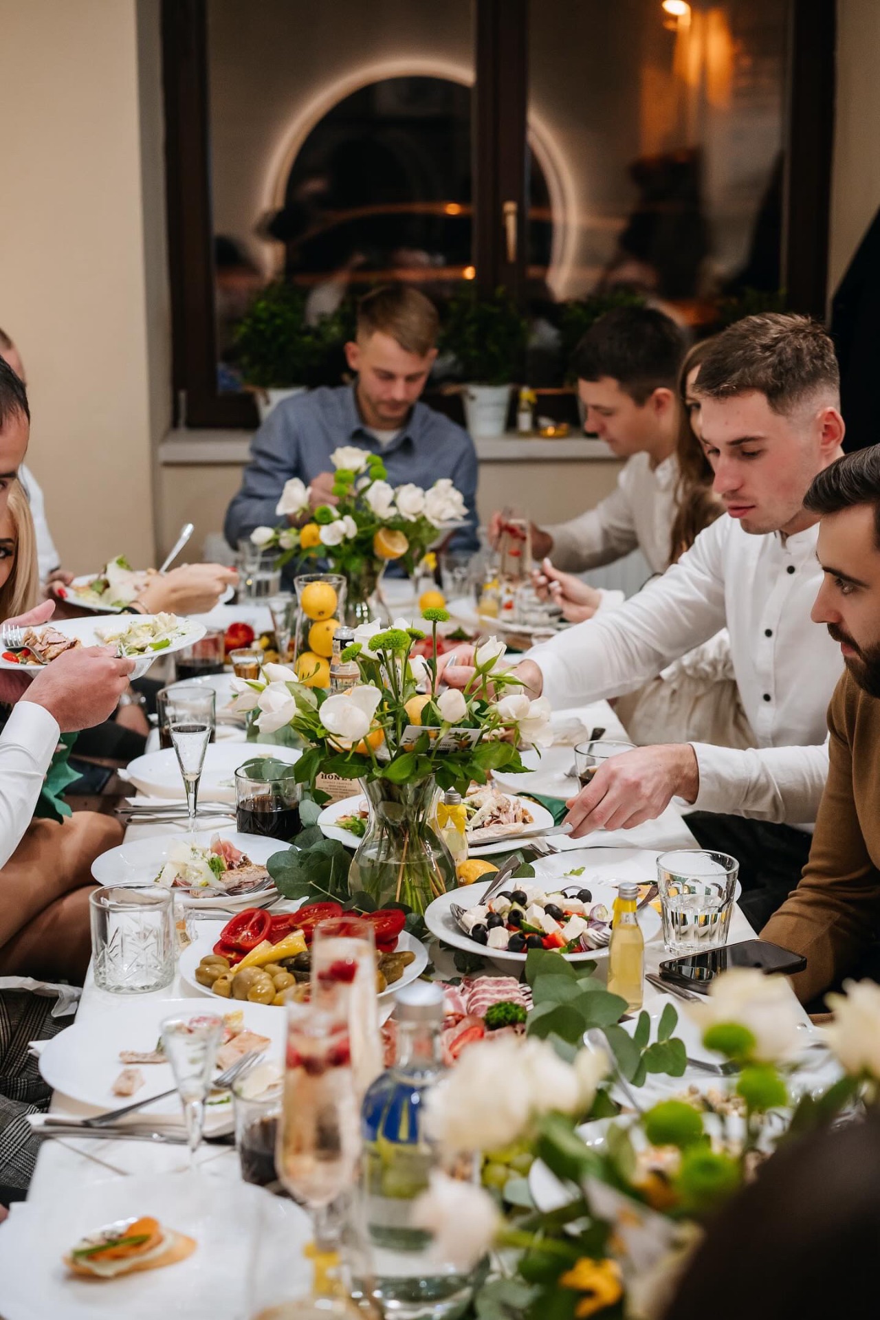Společnost u slavnostně prostřeného stolu v Bistro Sugar